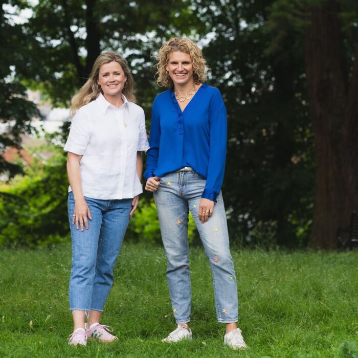 Camilla Rigby and Rachel Mostyn standing on green grass with tress in the background and smiling